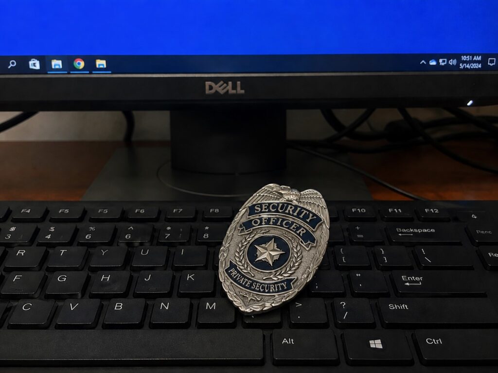 Texas private security officer badge resting on a keyboard in front of a computer, representing the online Level 2 course
